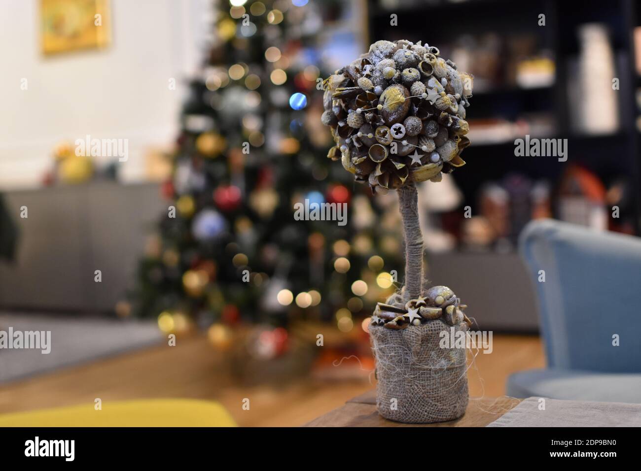 Weihnachten hausgemachte Dekoration auf einem festlichen Tisch mit beleuchtet Baum im Hintergrund Stockfoto