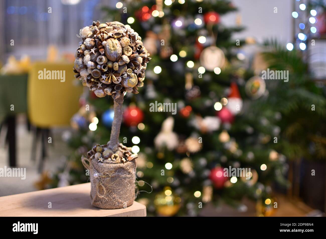 Weihnachten hausgemachte Dekoration auf einem festlichen Tisch mit beleuchtet Baum im Hintergrund Stockfoto