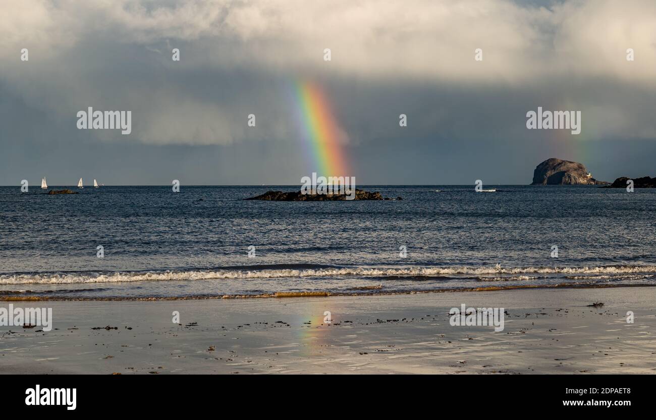 North Berwick, East Lothian, Schottland, Großbritannien, 19. Dezember 2020. UK Wetter: Ein doppelter Regenbogen erscheint nach Regen, der den Firth of Forth und den Bass Rock aufschlägt und sich im nassen Sand am Strand widerspiegelt Stockfoto