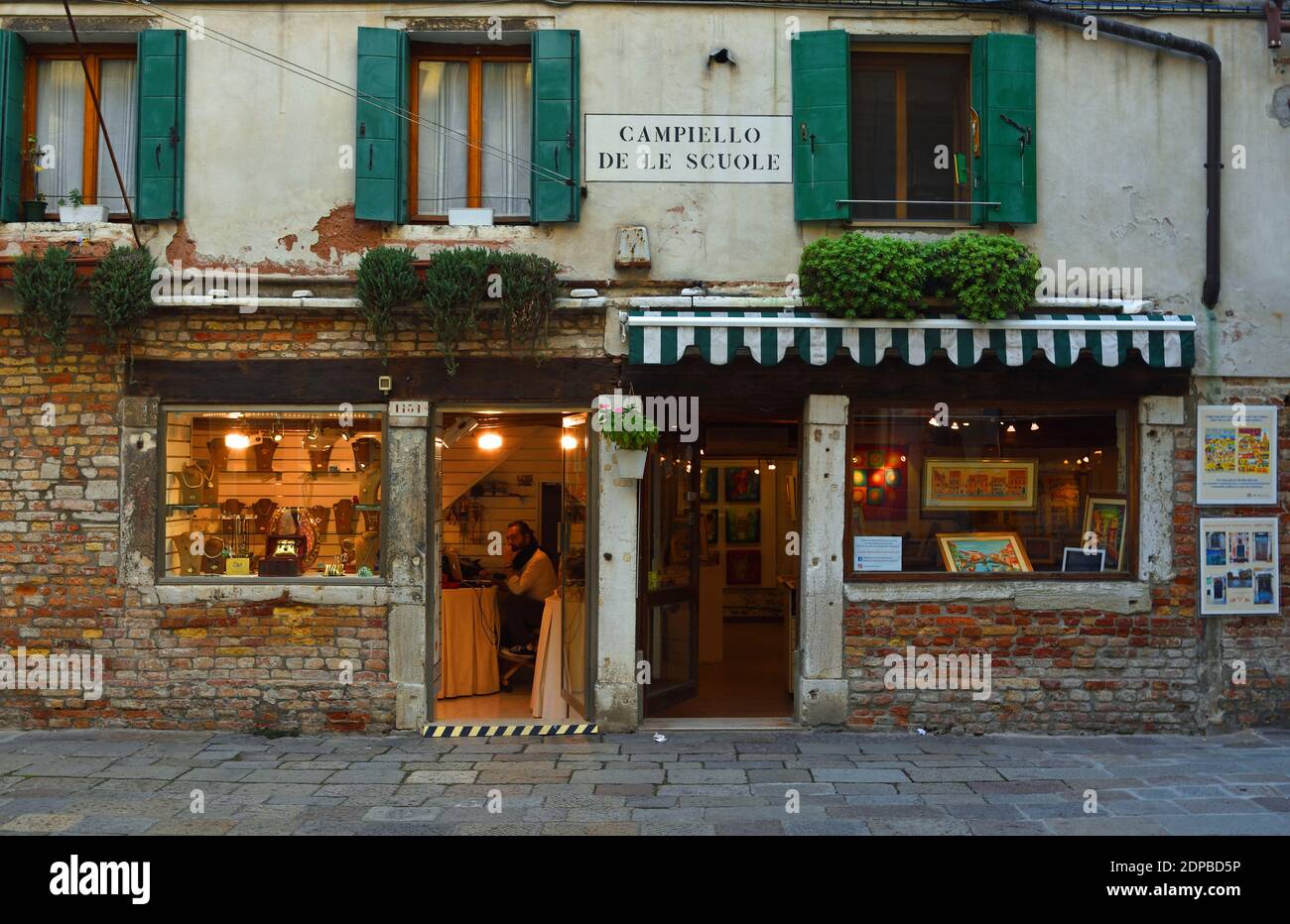 Old Shop befindet sich vor einem Juwelier und einer Kunstgalerie in Venedig in der Nähe des jüdischen Viertels, das am frühen Abend aufgenommen wurde. Stockfoto