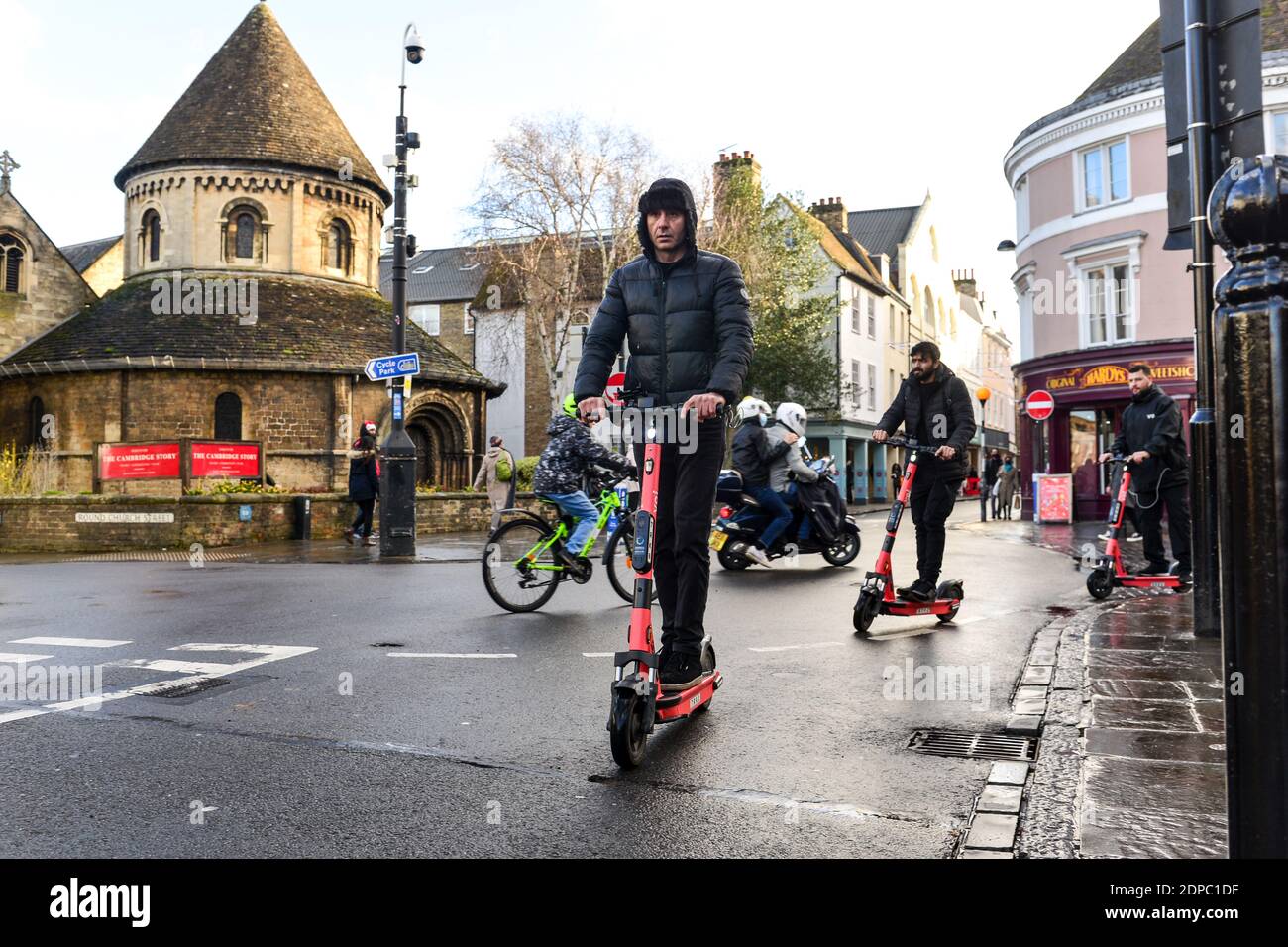 Cambridge, Großbritannien, 19-12-2020. Erwachsene fahren entlang der Straße mit den neuen Elektrorollern, die über eine App im Touristenziel von Cambridge abgerufen werden Stockfoto