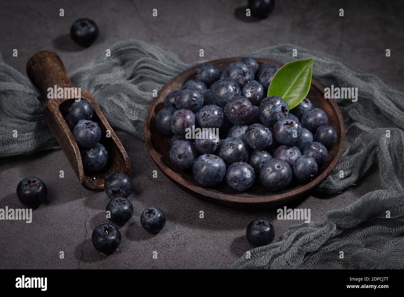 Gericht mit einem Bündel Heidelbeeren auf dunklem Hintergrund. Stockfoto