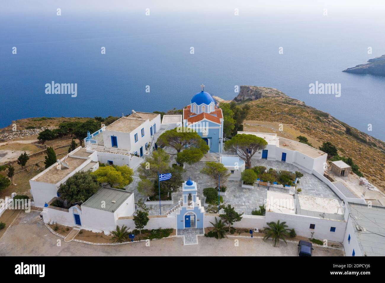Griechenland. Kea Insel, Kastriani Kloster, blaues Meer Hintergrund. Luftdrohne Ansicht der Kirche und weiß getünchten Gebäuden Stockfoto
