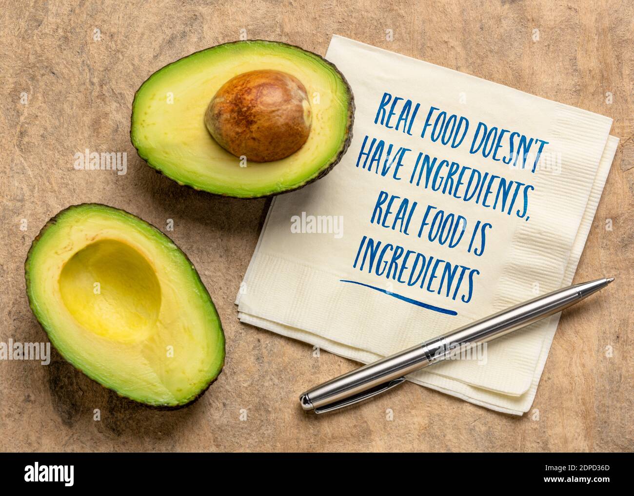 Echtes Essen hat keine Zutaten, es sind Zutaten - Handschrift auf einer Serviette mit Avocado-Frucht, gesunde Ernährung und Lifestyle-Konzept Stockfoto