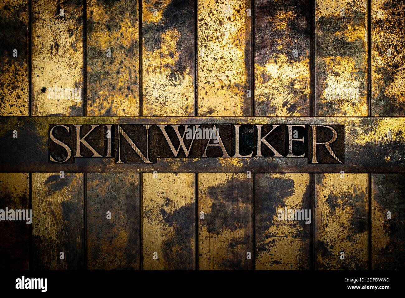 Skinwalker Text auf grunge texturiertem Kupfer und Gold Hintergrund Stockfoto