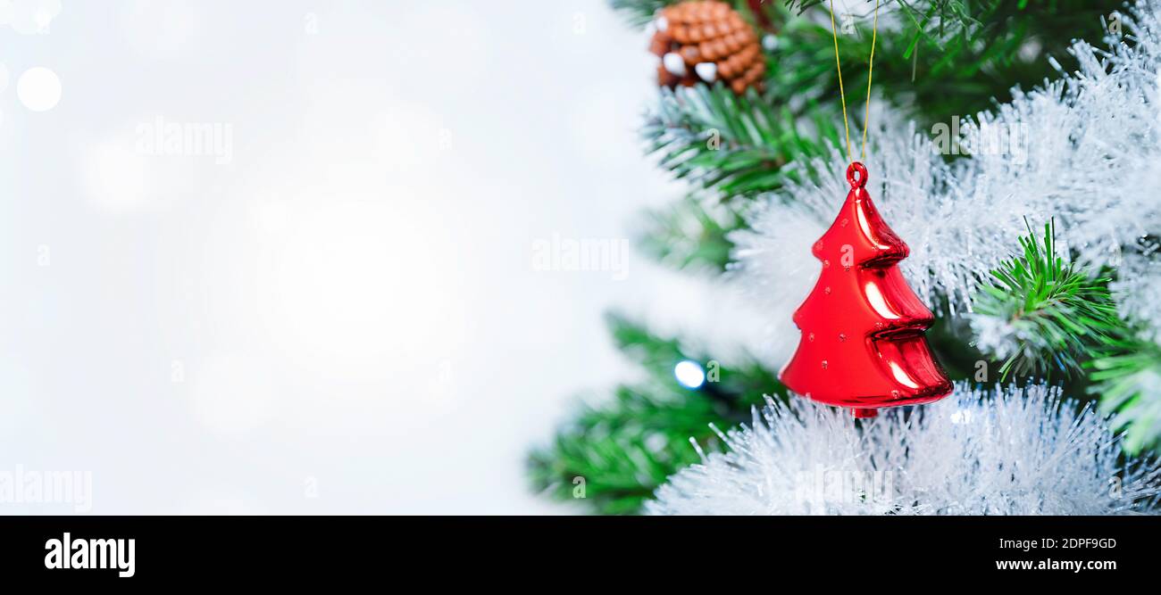 Weihnachtsbaum mit Dekoration aus nächster Nähe. Weihnachtskugel auf einem Zweig. Horizontales helles Banner mit Kopierbereich Stockfoto