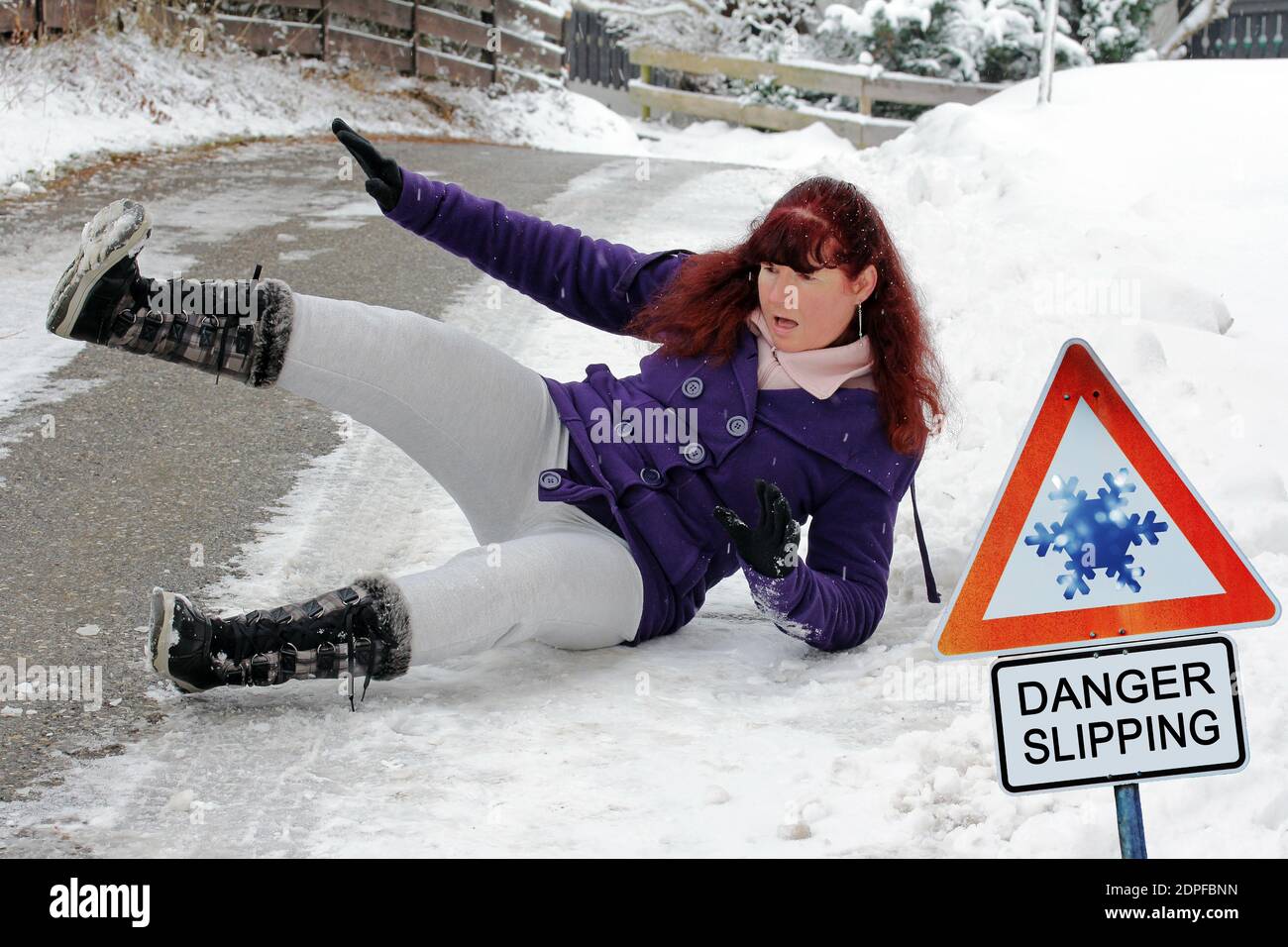 Unfallgefahr im Winter. Eine Frau rutscht auf der glatten Straße aus Stockfoto