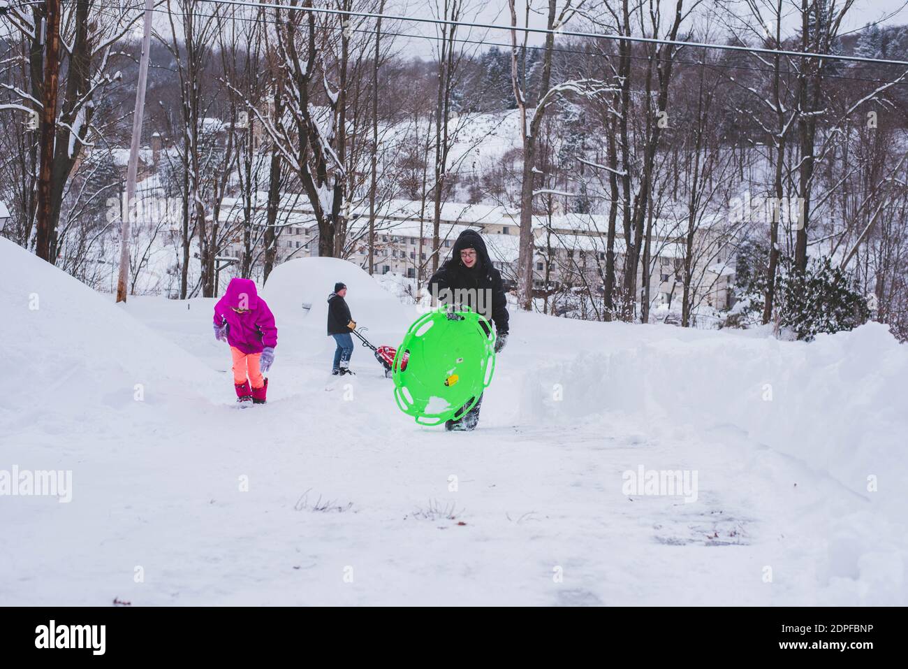 Kinder klettern im Winter auf und ab einen schneebedeckten Hügel. Stockfoto