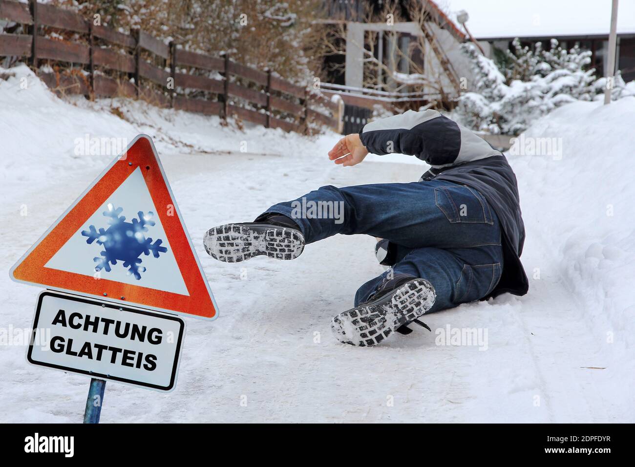 Unfallgefahr im Winter. Ein Mann rutscht auf der glatten Straße aus Stockfoto