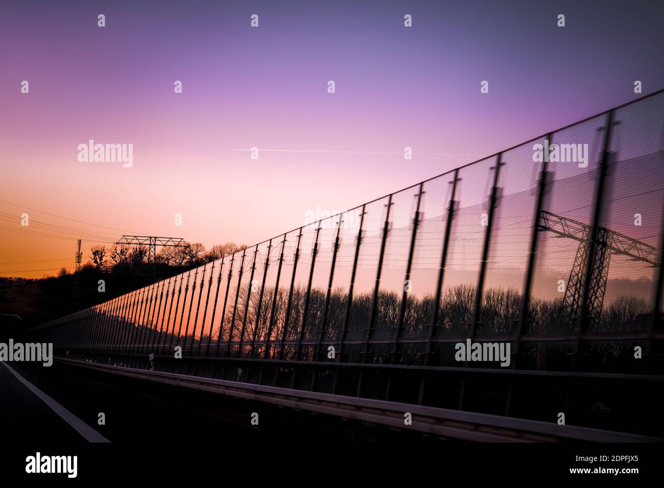 Lila Sonnenuntergang auf einer reflektierenden Oberfläche auf der Autobahn Stockfoto