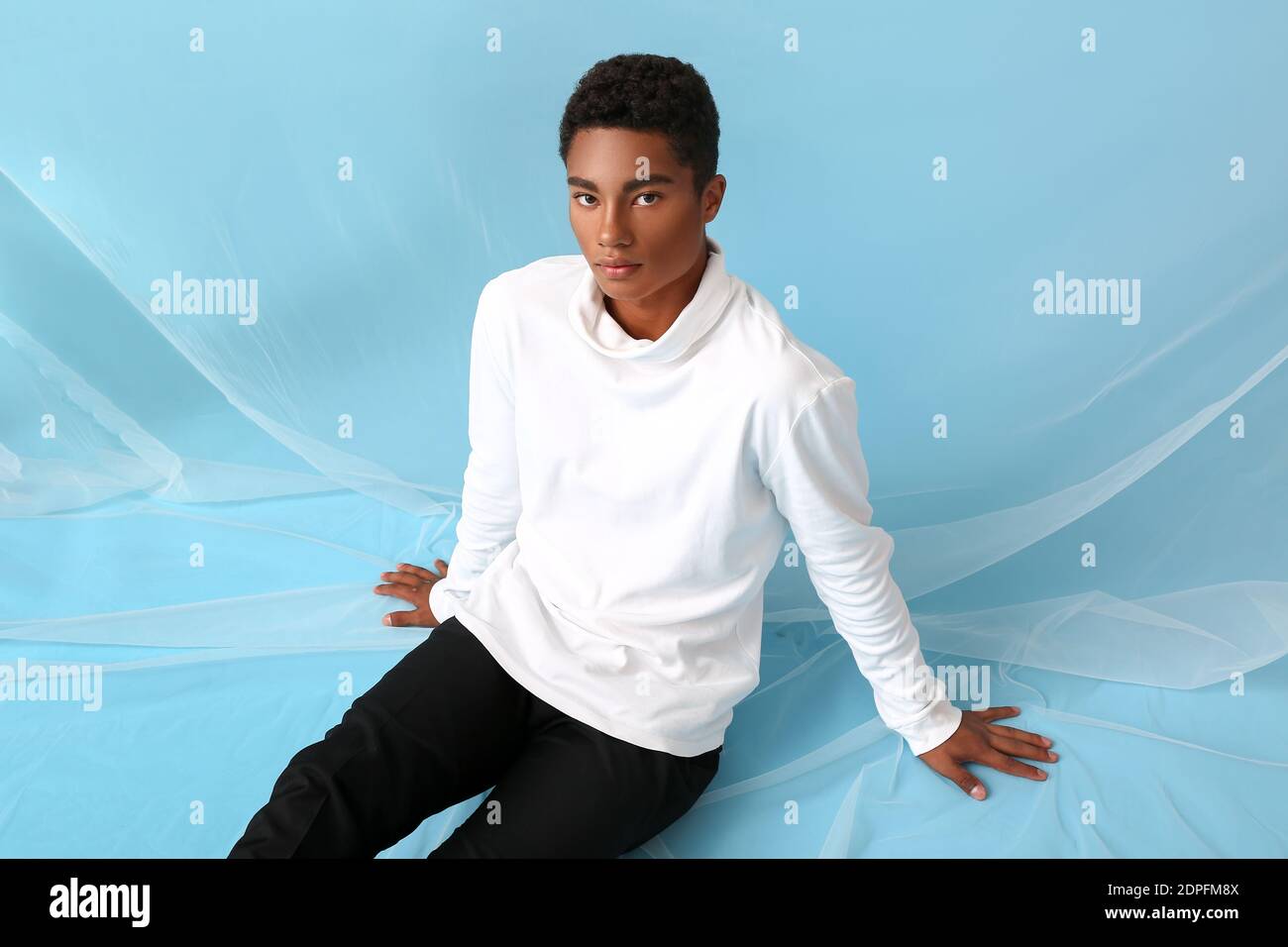 Stilvoller junger afroamerikanischer Mann auf farbigem Hintergrund Stockfoto