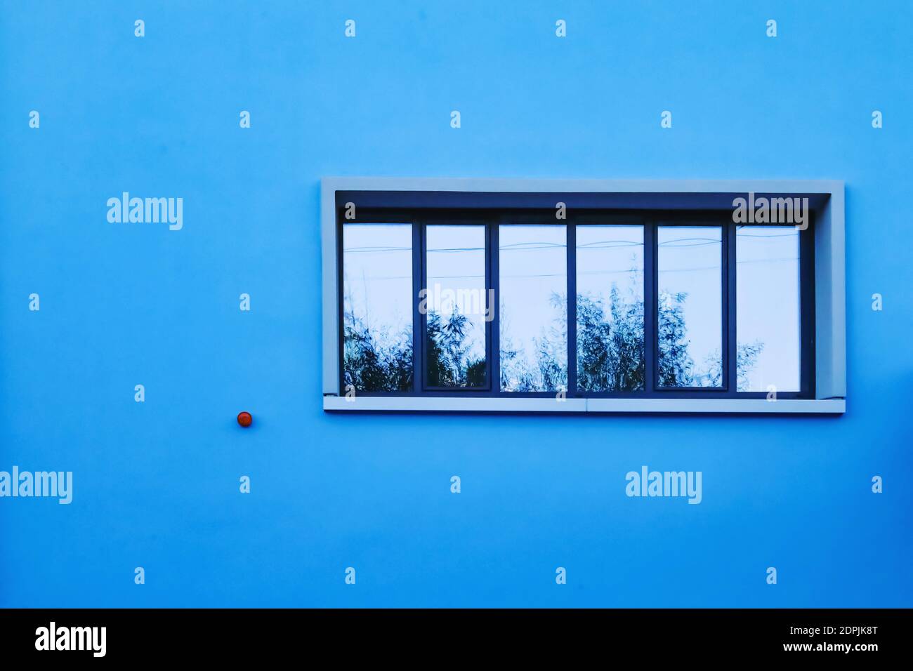 Blaue Wand mit EINEM Fenster, das den Himmel reflektiert Stockfotografie -  Alamy