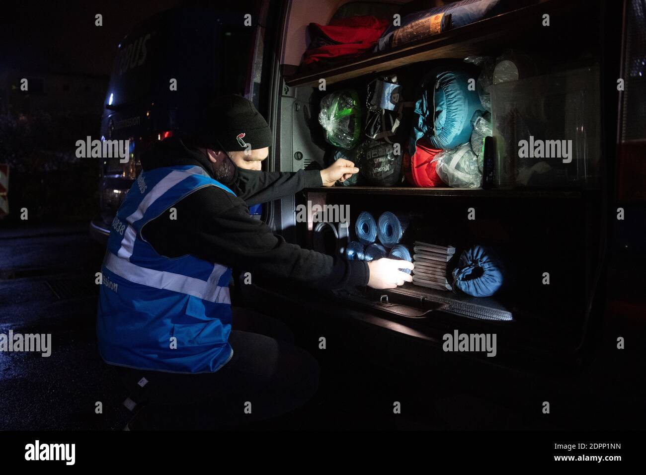 Berlin, Deutschland. Dezember 2020. Philip, Volunteer des kalten Busses der Stadtmission, prüft vor Reiseantritt, ob genügend Schlafsäcke und isolierte Matten für Obdachlose im Kofferraum sind. Quelle: Paul Zinken/dpa/Alamy Live News Stockfoto