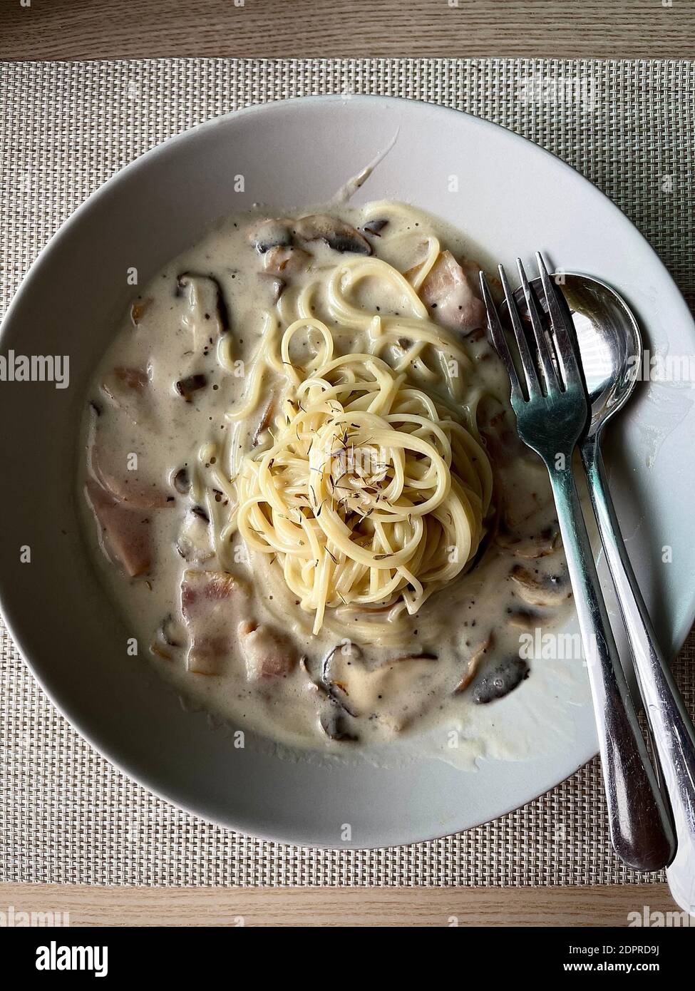 Spaghetti Cabonara Pasta mit weißer Sahne-Sauce, Speck und Hühnchen Schinken auf natürlichen Holztisch Stockfoto