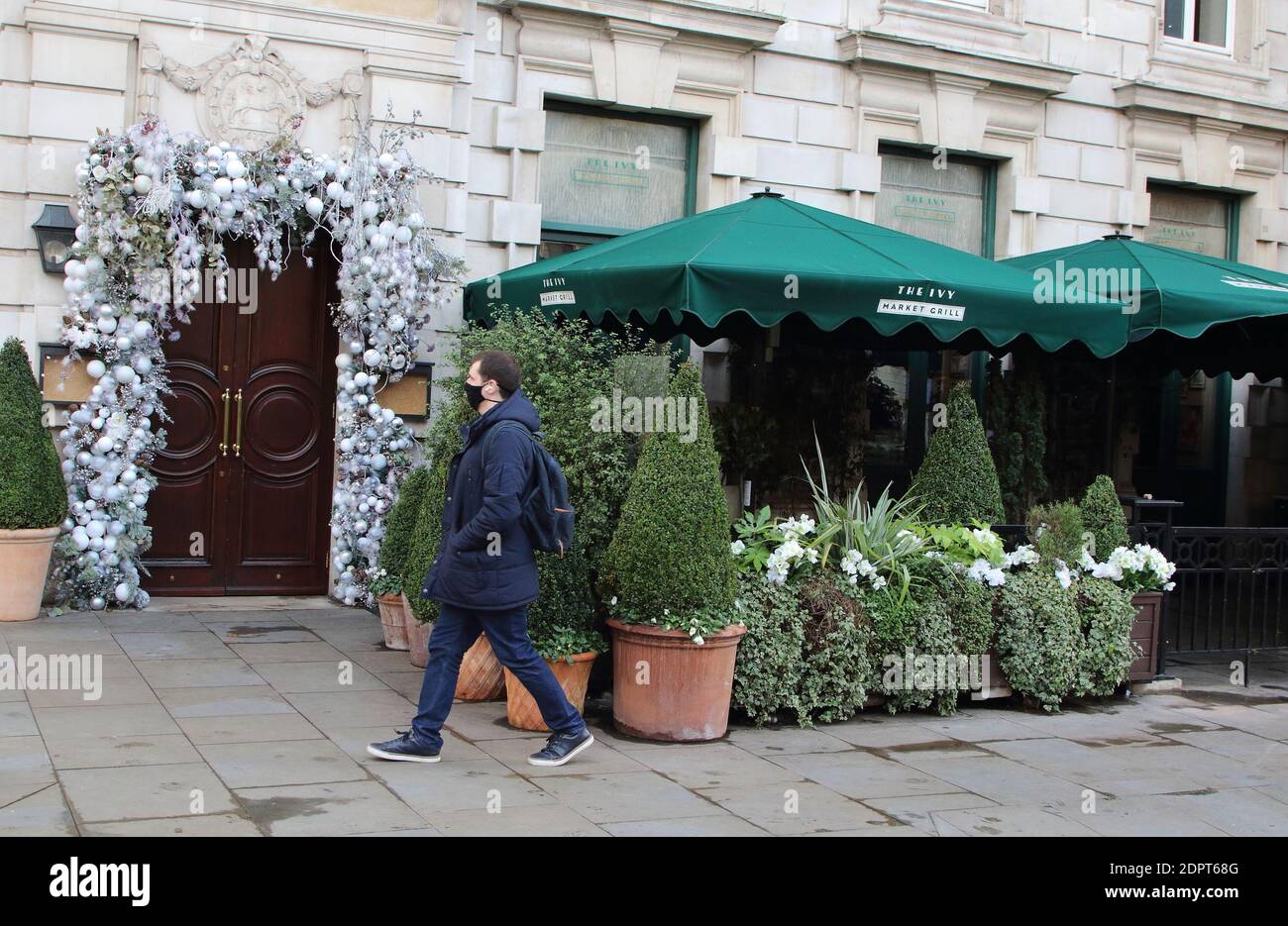 Ein Mann geht an einem geschlossenen Restaurant des Ivy in Covent Garden vorbei.London tritt in die strengen Tier 4-Beschränkungen ein, da neue Mutant Covid-19-Sorte gefunden wird. Die neue Variante des Virus wurde festgestellt, dass 70% mehr infektiöse und ist derzeit in ganz London und dem Südosten von England grassiert. Stockfoto