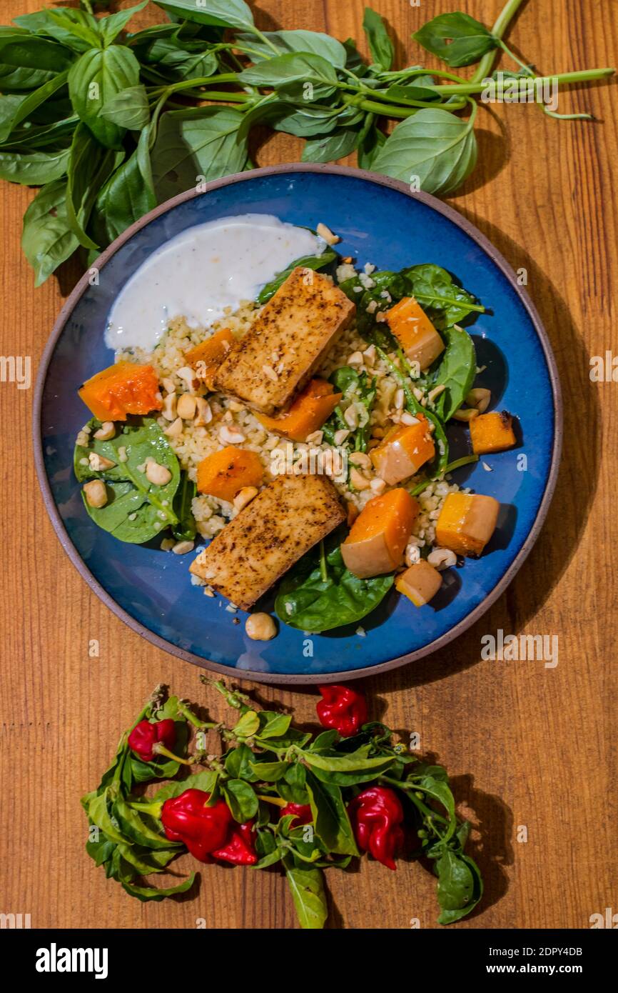 Gesunder Teller mit gebratenem vegetarischem Tofu und griechischer Halloumi mit gegrilltem Gemüse und Joghurtsauce. Mediterrane Gerichte mit orientalischem Couscous Stockfoto