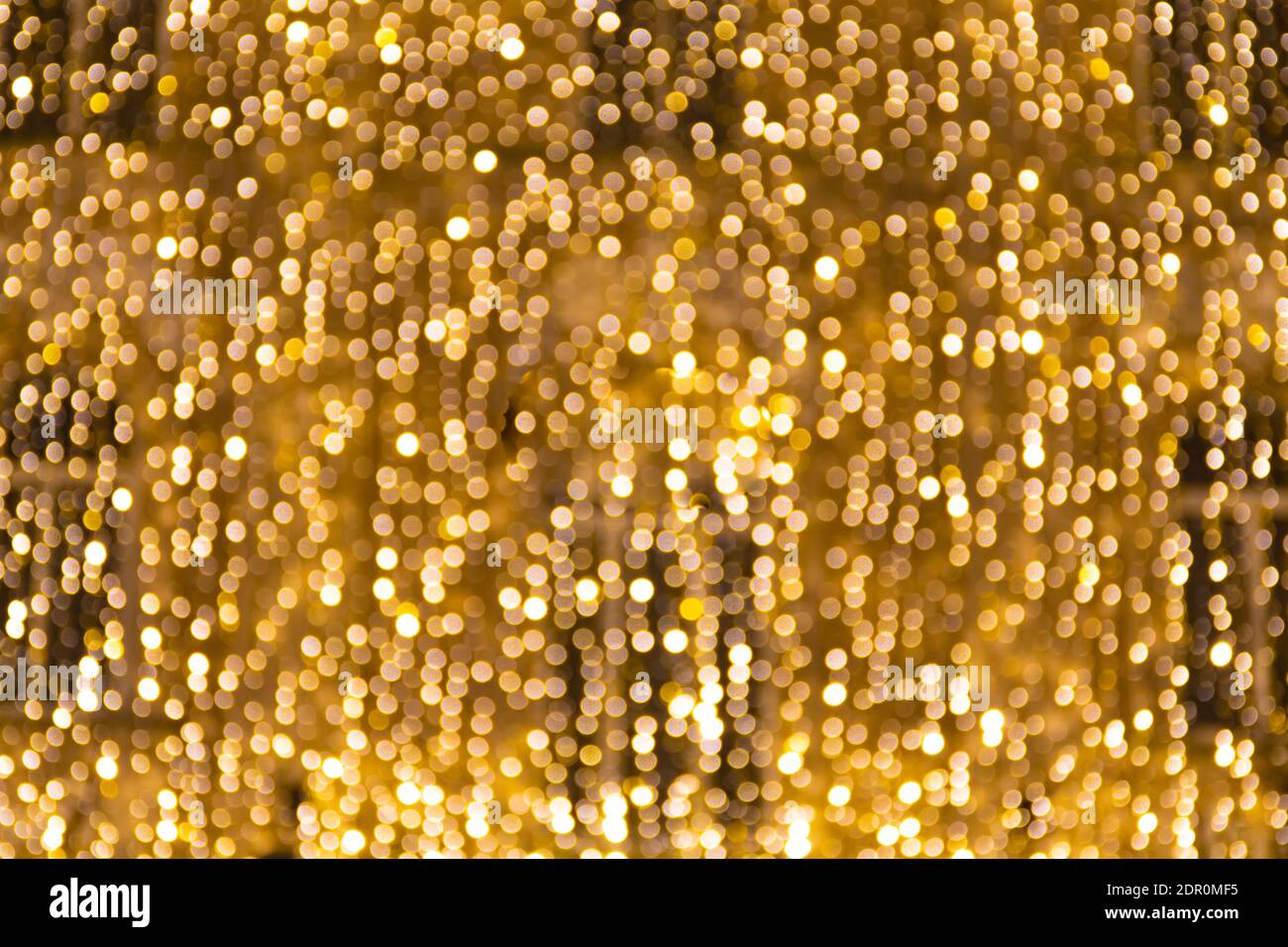 Magischer abstrakter Hintergrund mit gelben Bokeh-Lichtern, warmem Gefühl, Wärme, Party oder Feier, Vorhang oder Kaskade von Lichtern Stockfoto