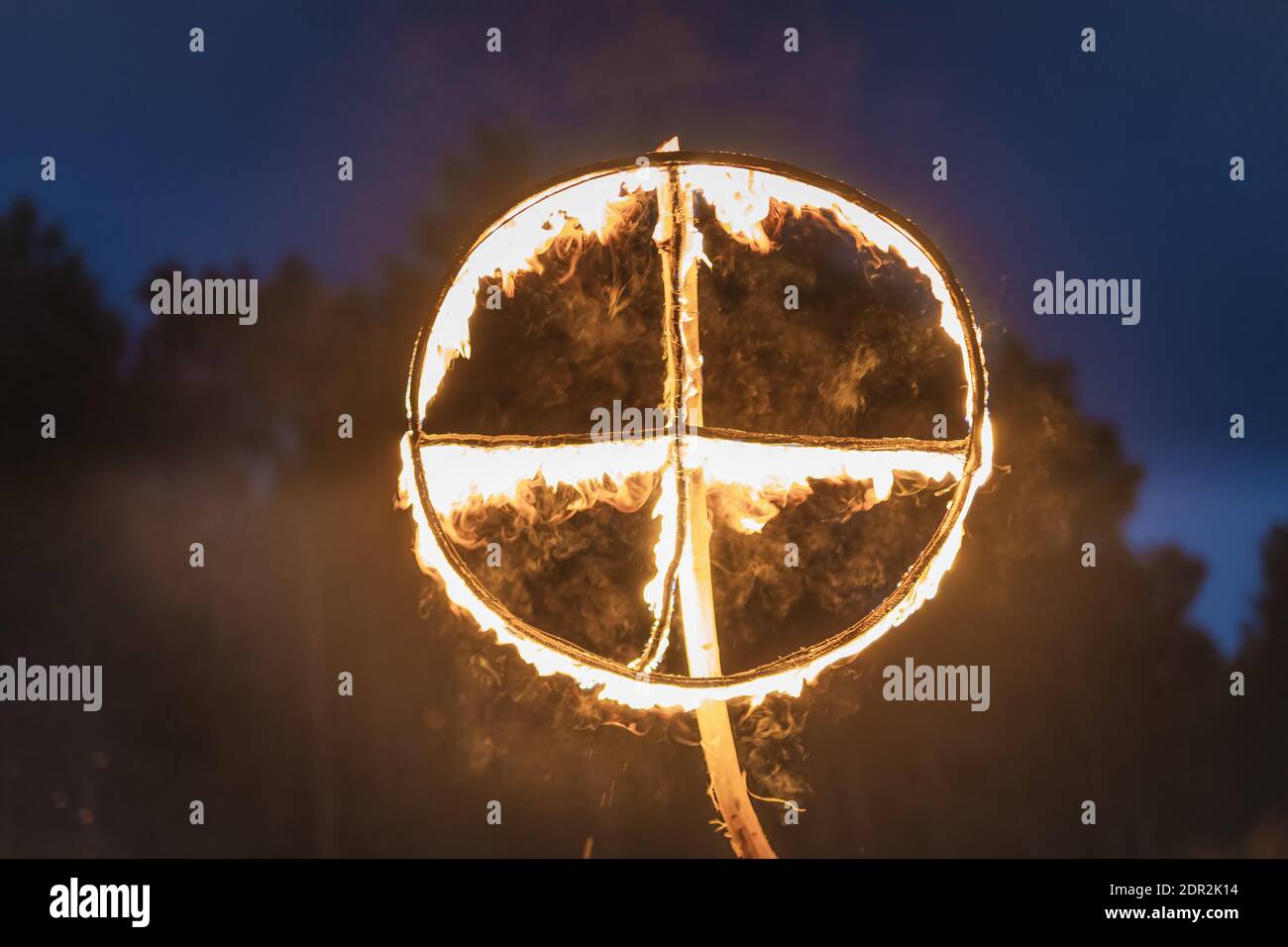 Brennendes Symbol der Sonne, ein Sonnenkreuz oder Sonnenrad bei heidnischer Nachstellung der Kupala-Nacht, in Polen Noc Kupaly genannt. Stockfoto