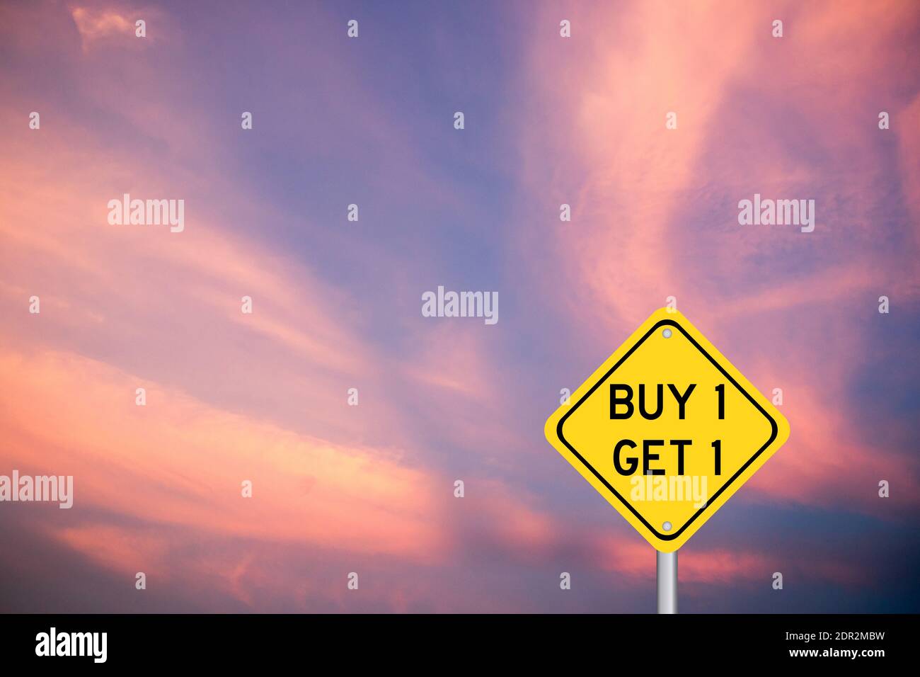 Gelbe Farbe Transport-Schild mit Wort kaufen 1 erhalten 1 Auf violettem Wolkenhimmel Hintergrund Stockfoto