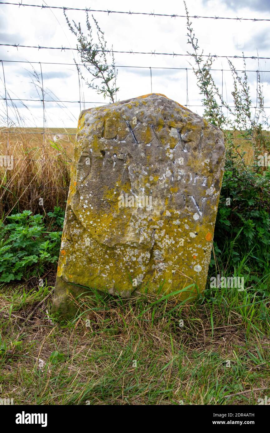 Alter verwitterter Meilenstein mit einigen Schriftzügen noch in der Nähe von Stonehenge sichtbar Stockfoto
