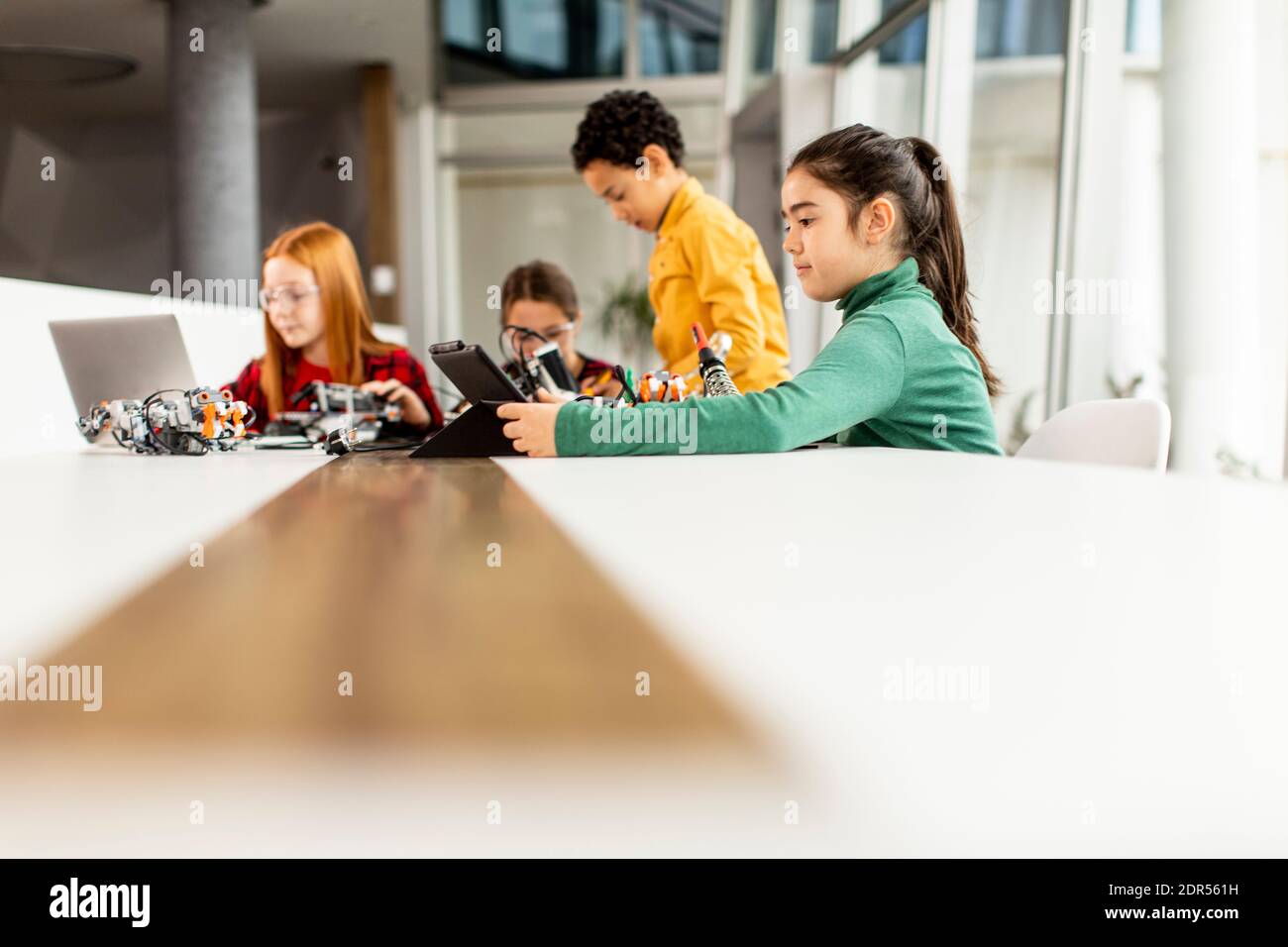 Gruppe von glücklichen Kindern Programmierung elektrische Spielzeug und Roboter an Robotik-Klassenzimmer Stockfoto
