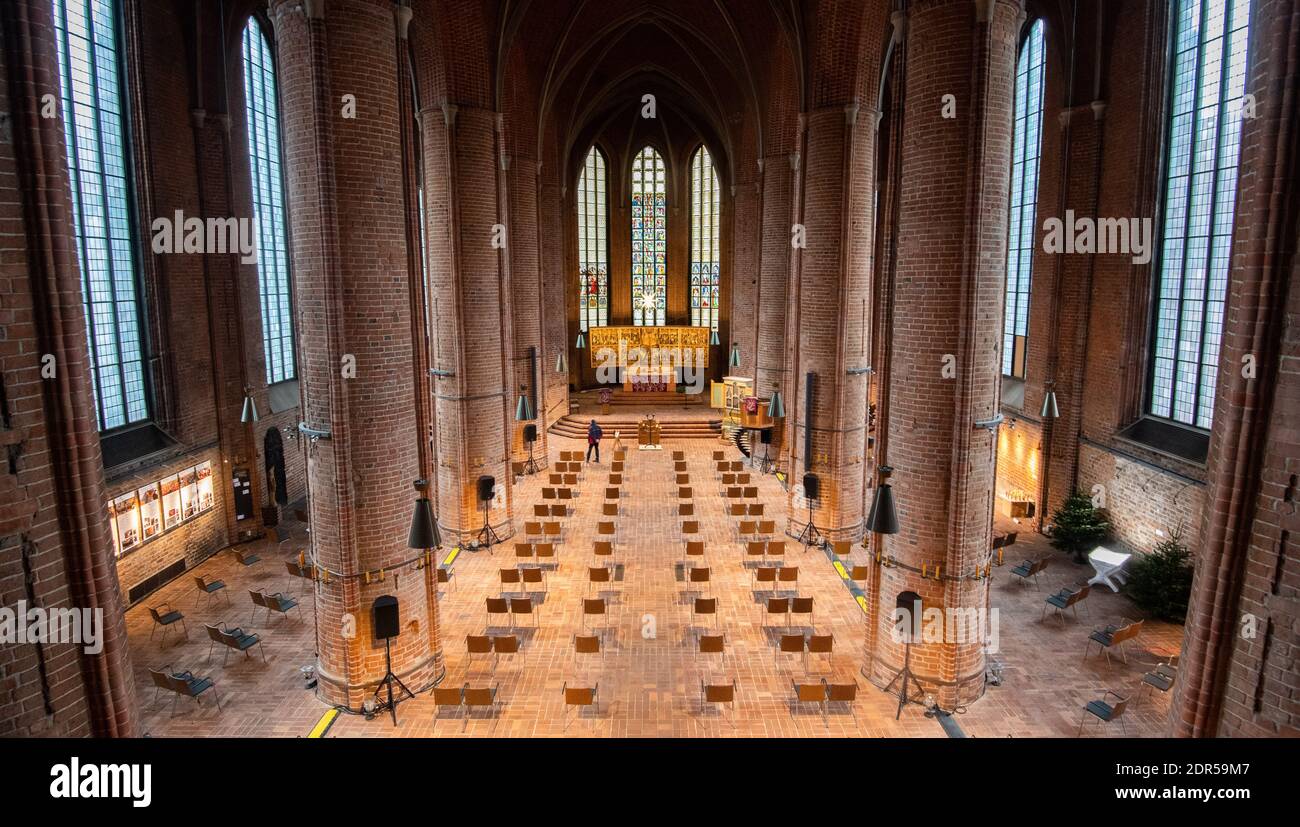 Hannover, Deutschland. Dezember 2020. Die in der Marktkirche in Hannover angeordneten Stühle halten den erforderlichen Abstand für die Weihnachtsmessen ein. Maximal 190 Personen können die Marktkirche besuchen. Eine Umfrage zeigt, dass die Hälfte der Deutschen in diesem Jahr wegen der Coronavirus-Pandemie lieber Weihnachtsmassen verbieten würde. Kredit: Julian Stratenschulte/dpa/Alamy Live Nachrichten Stockfoto