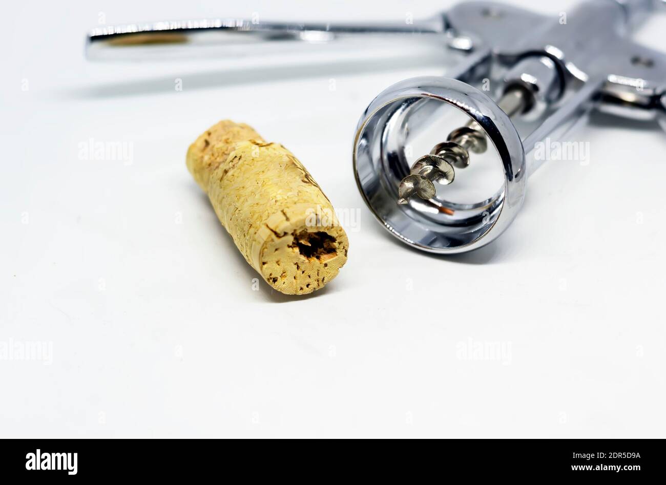 Stahlkorkenzieher mit einem perforierten Korken isoliert auf weißem Hintergrund. Stockfoto
