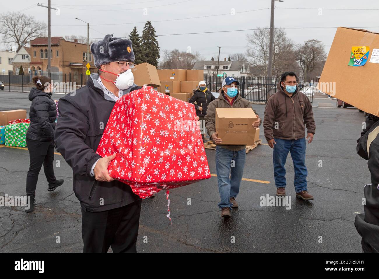 Detroit, Michigan, USA. Dezember 2020. In der katholischen Kirche St. Hedwig lieferte der muslimische Gemeinderat von Michigan in Partnerschaft mit St. Hedwig's Lebensmittelkartons und Weihnachtspakete an bedürftige Familien. Freiwillige legten Kisten in Autos, als sie durch den Kirchparkplatz fuhren. Die Lebensmittel-Boxen kamen aus dem US-Landwirtschaftsministerium. Kredit: Jim West/Alamy Live Nachrichten Stockfoto