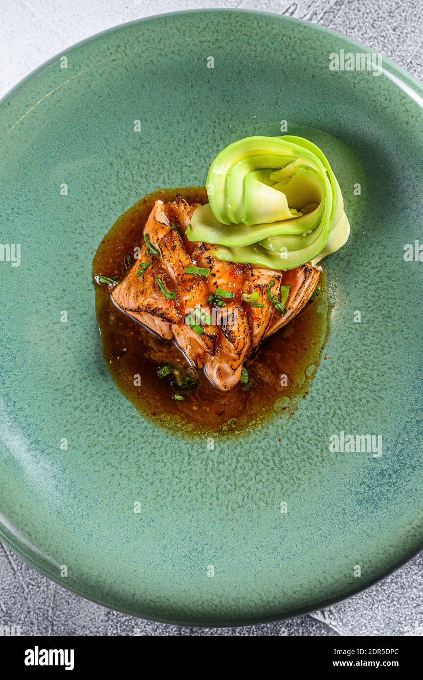 Lachsfilet Tataki mit Avocado-Garnitur. Grauer Hintergrund. Draufsicht. Stockfoto