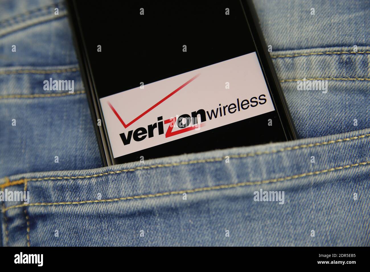 Viersen, Deutschland - 9. Mai. 2020: Nahaufnahme des Smartphone-Bildschirms in blauer Jeans-Tasche mit Logo-Schriftzug des amerikanischen Mobilfunkanbieters Verizon Wirel Stockfoto