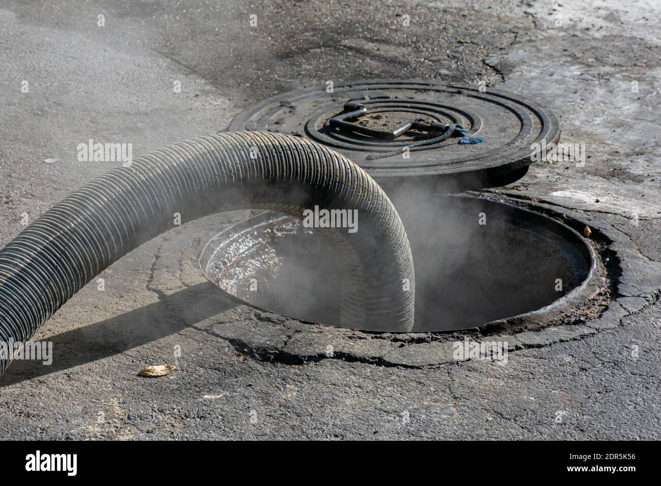 Schlauch, der an einen Tank am Boden angeschlossen ist und das Heizöl abführt, da das Produkt eine hohe Temperatur hat, treten Dämpfe durch die Entlüftung aus. Stockfoto