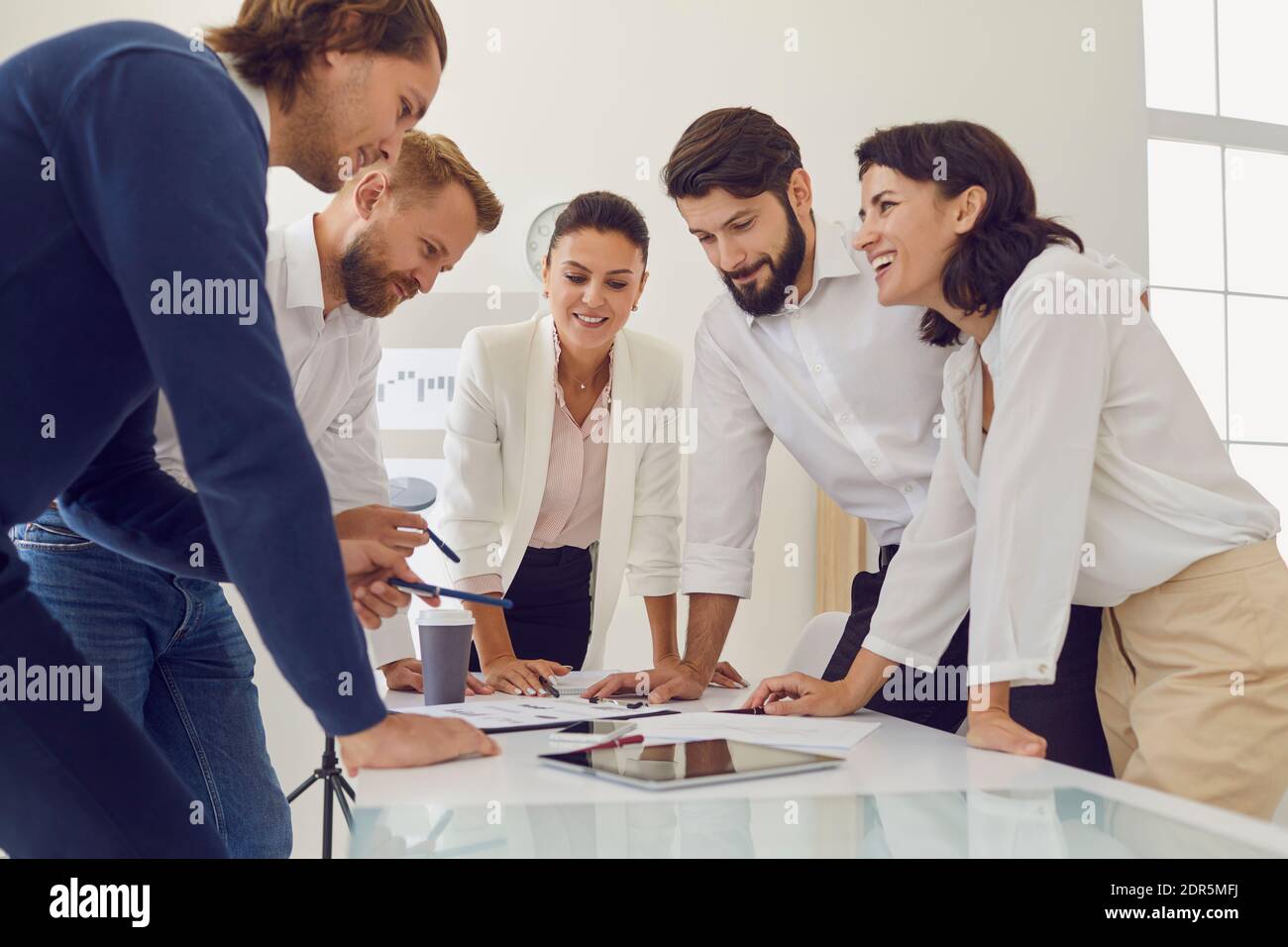 Gruppe von jungen lächelnden Büroangestellten Geschäftsleute dusscussing neu Gemeinsam im Büro projizieren Stockfoto