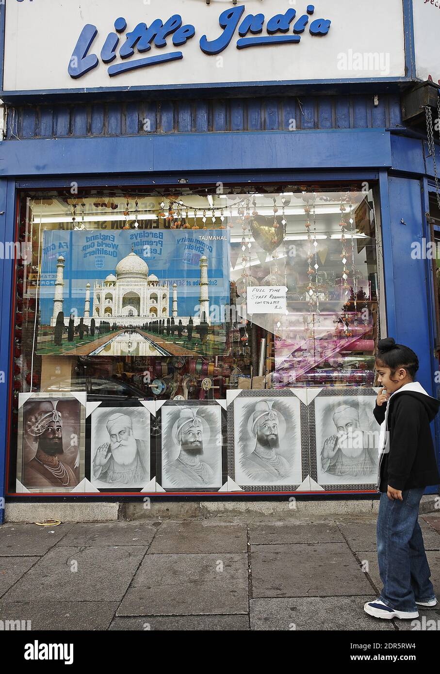 Sikh Junge vorbei kleinen Indien-Shop . Punjabi und asiatische Geschäfte in Southall London, England Stockfoto