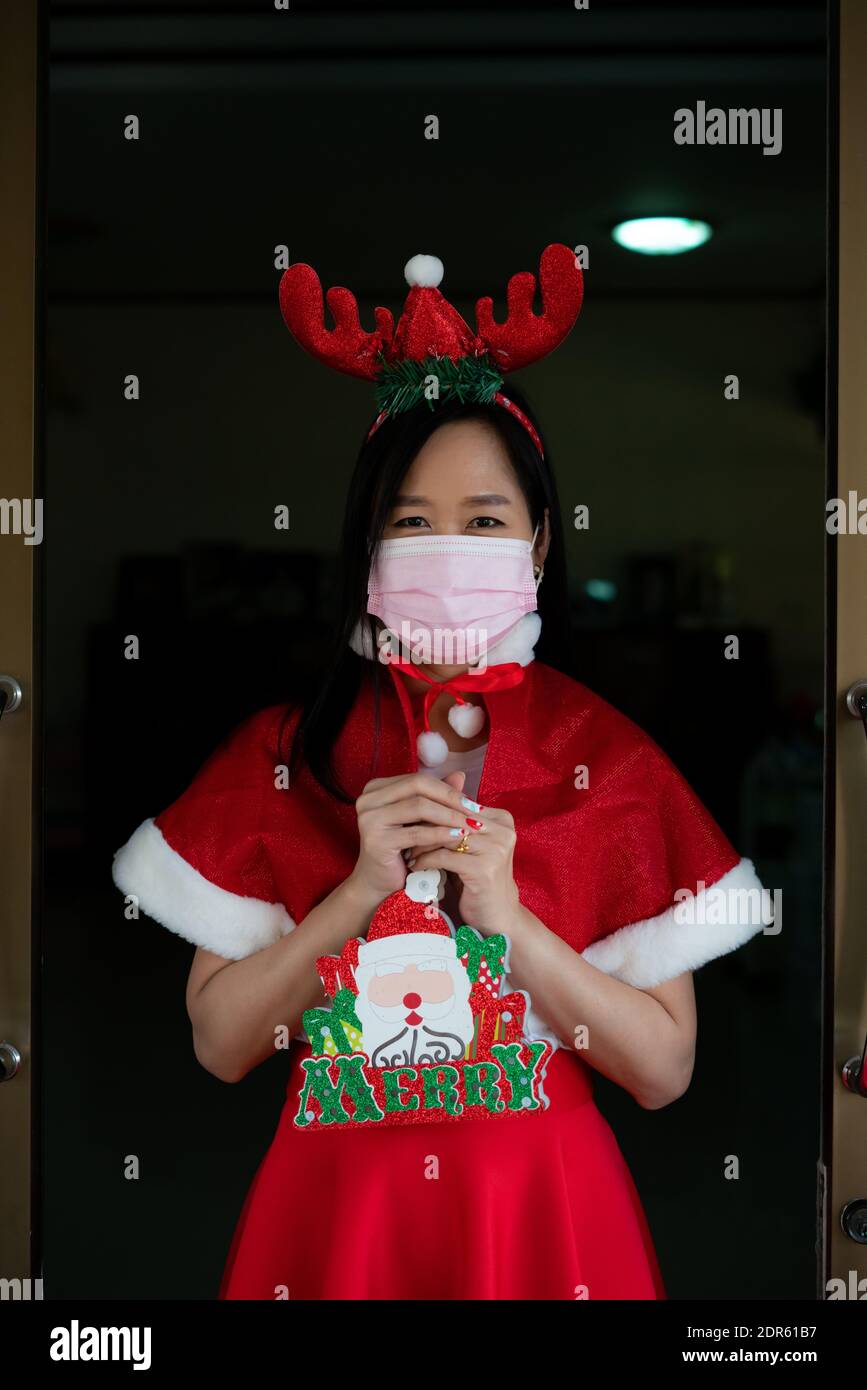 Frau im Weihnachtsmann Anzug mit Gesichtsmaske tragen in weihnachtstag Stockfoto