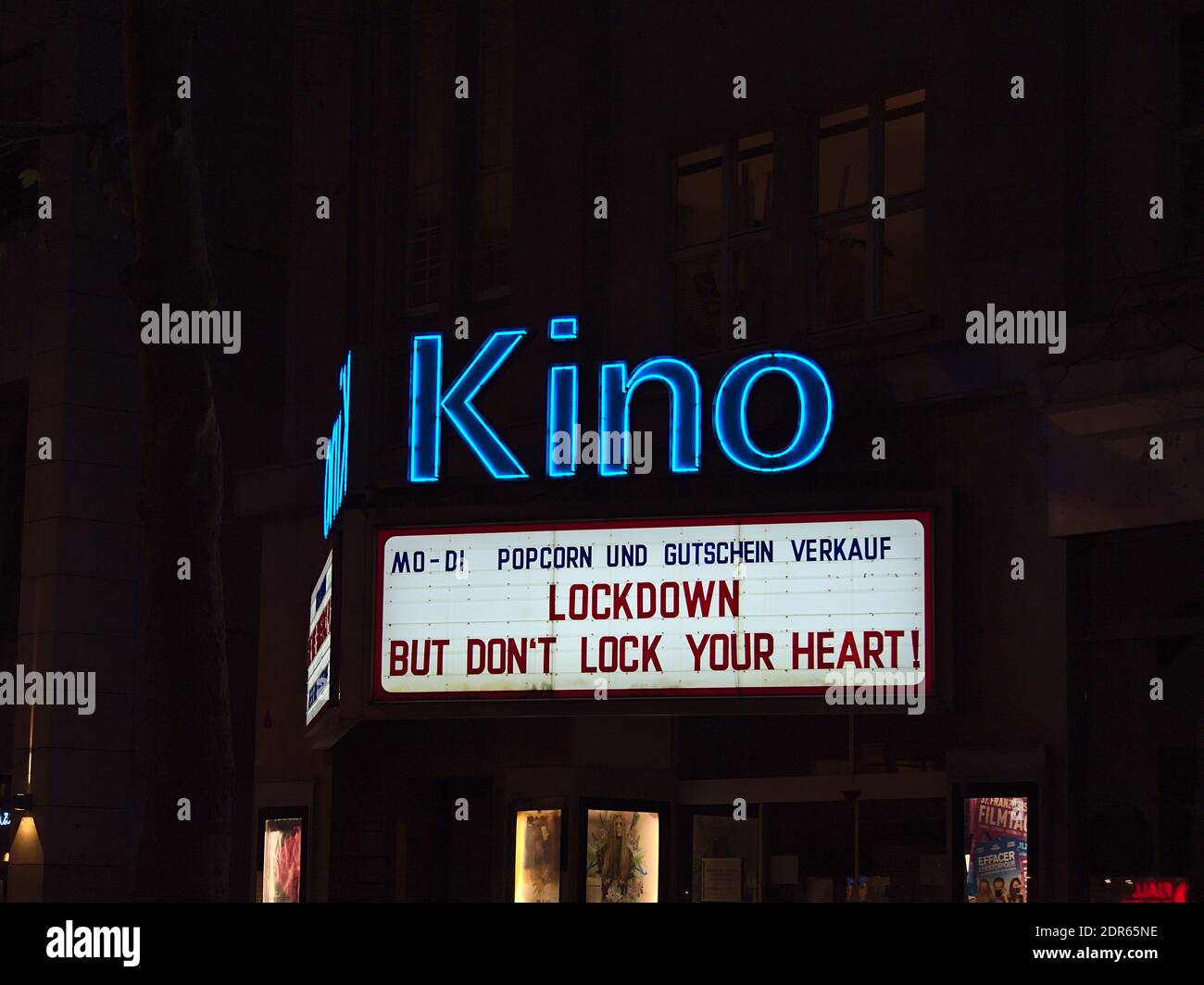 Beleuchtete Plakatwand über dem Kino ('Kino') geschlossen wegen Covid-19 Sperre im Stadtzentrum mit Slogan. Stockfoto