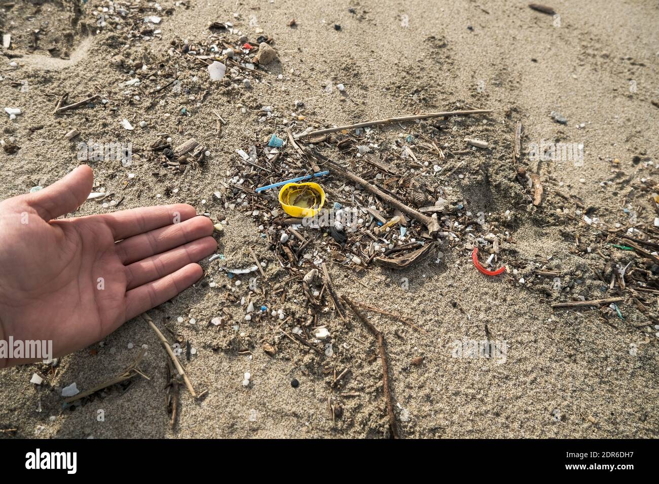 Mann sammeln Mikro-Plastikmüll auf schmutzigen Ozeanküste Ökosystem, Natur Verschmutzung Stockfoto