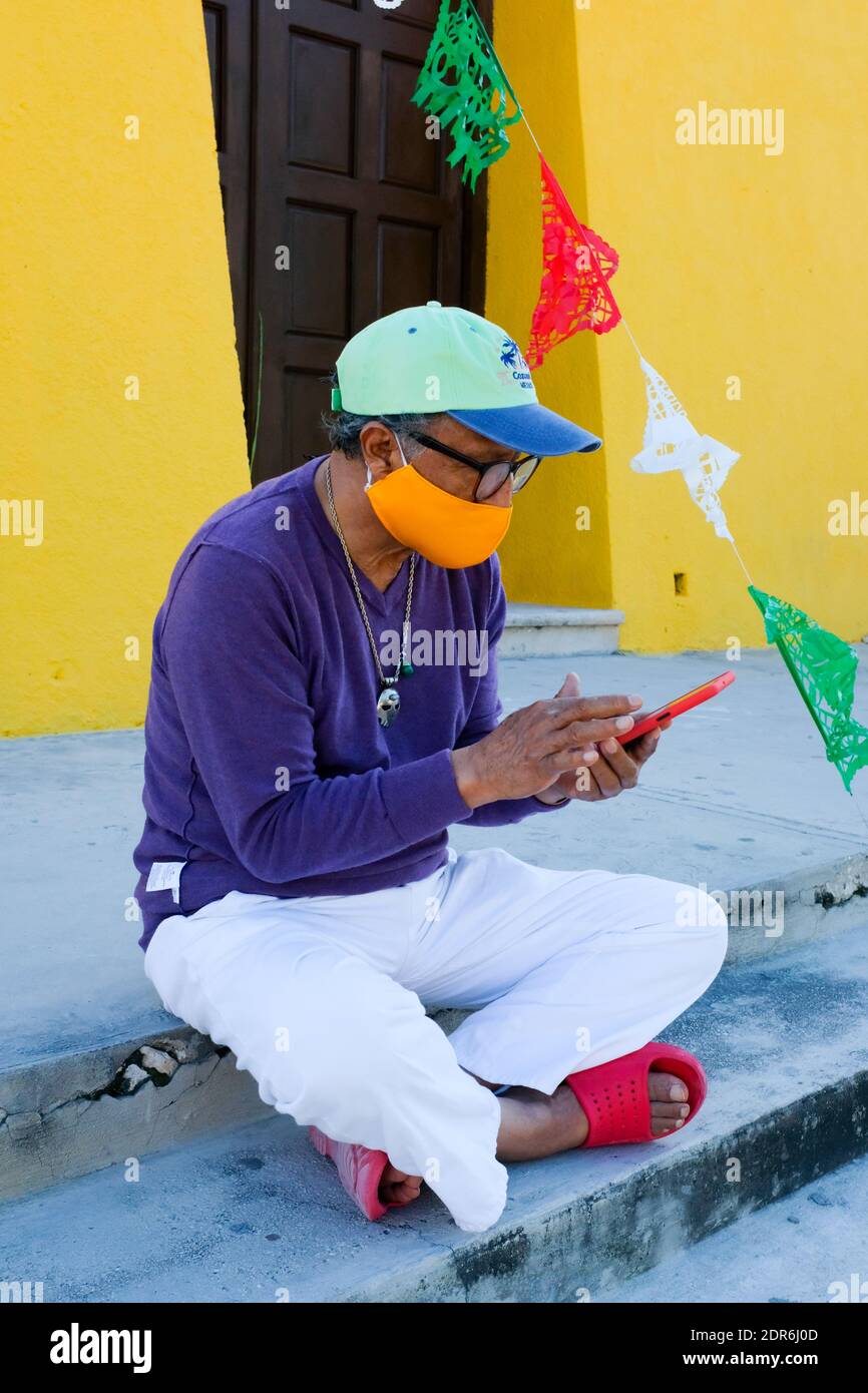 Mexikanischer Mann, der sein Telefon benutzt, um die Covid-19 Pandemie zu verfolgen, Yucatan Mexiko Stockfoto