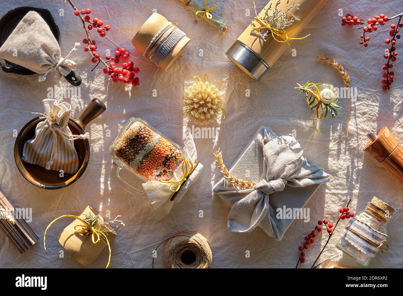 Weihnachtsgeschenke ohne Verschwendung. Geschichtete Einmachglas, Tassen, Kolben, Bürsten, Tassen und Schalen. Umweltfreundliche Geschenke, kein Plastik. Arrangement auf neutralem Leinen. Stockfoto