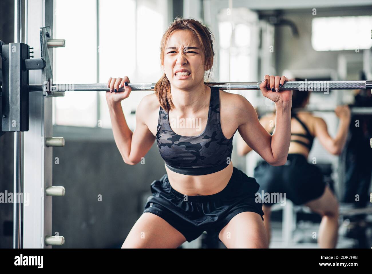Junge Frau, Die Gewichte Hebt, Während Sie Im Fitnessstudio Steht  Stockfotografie - Alamy