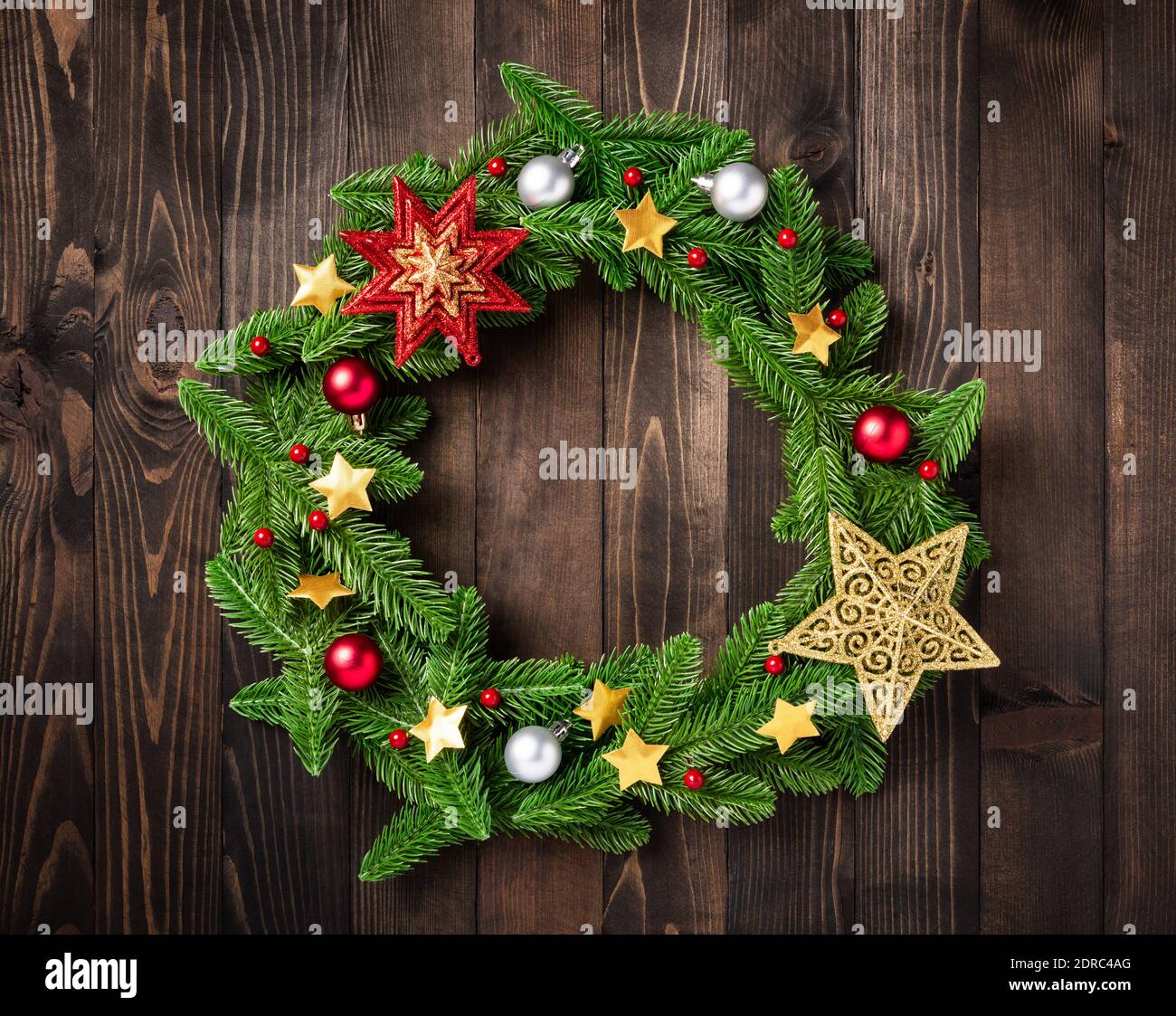 Weihnachtskranz mit Dekor, Draufsicht auf Baumtanne Fichtenzweige ist in einem Kreis gerollt und Ornament Stern auf schwarzem Tischholz Hintergrund, Neujahr fes Stockfoto