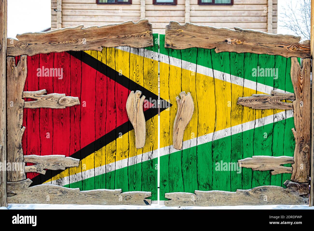 Nahaufnahme der Nationalflagge von Guyana auf einem Holztor am Eingang zum geschlossenen Gebiet. Das Konzept der Lagerung von Waren, Eintritt zu einem geschlossenen a Stockfoto