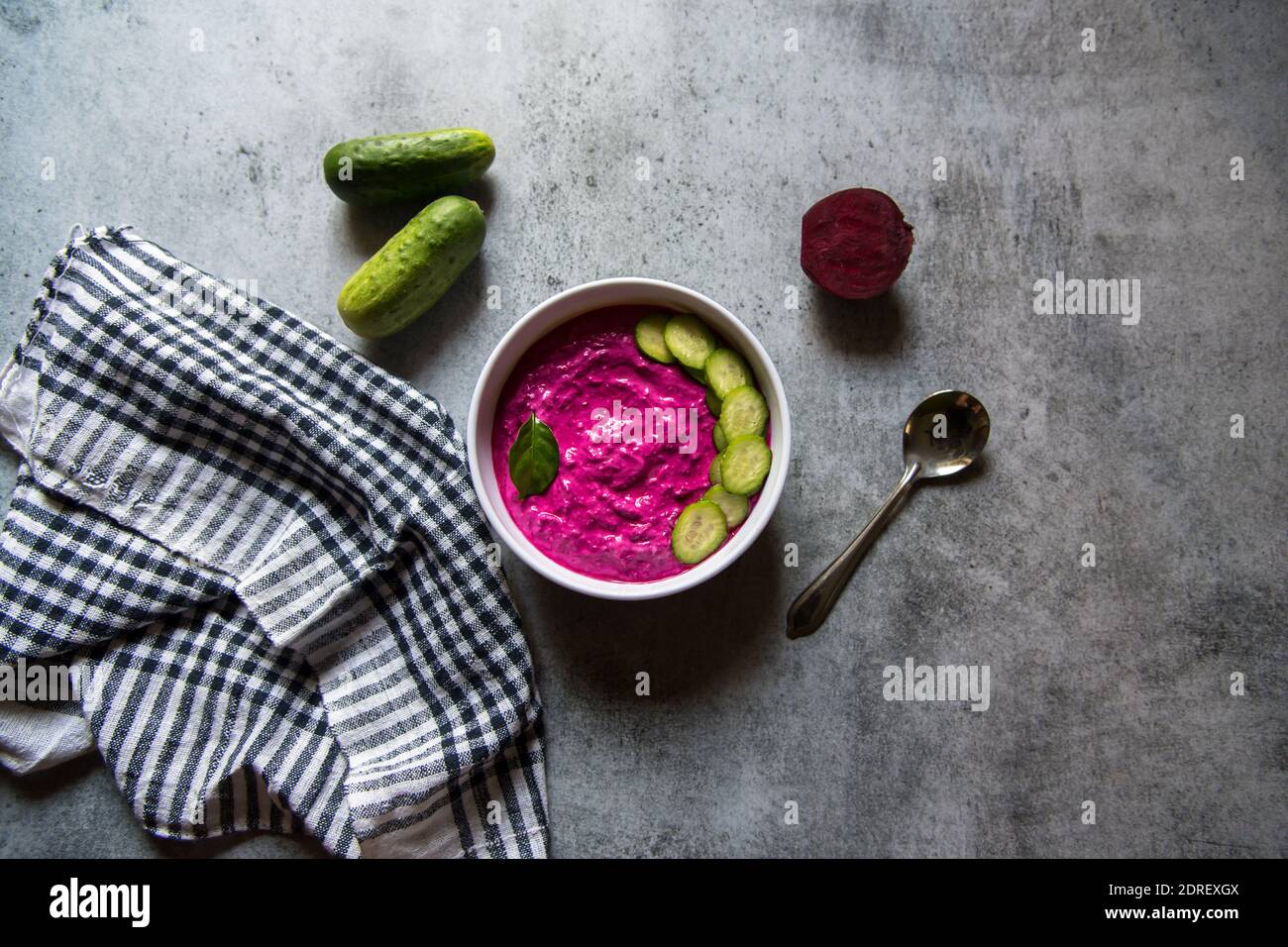 Rote Beete Dip und Gurkenscheiben in einer Schüssel auf einem Hintergrund Stockfoto