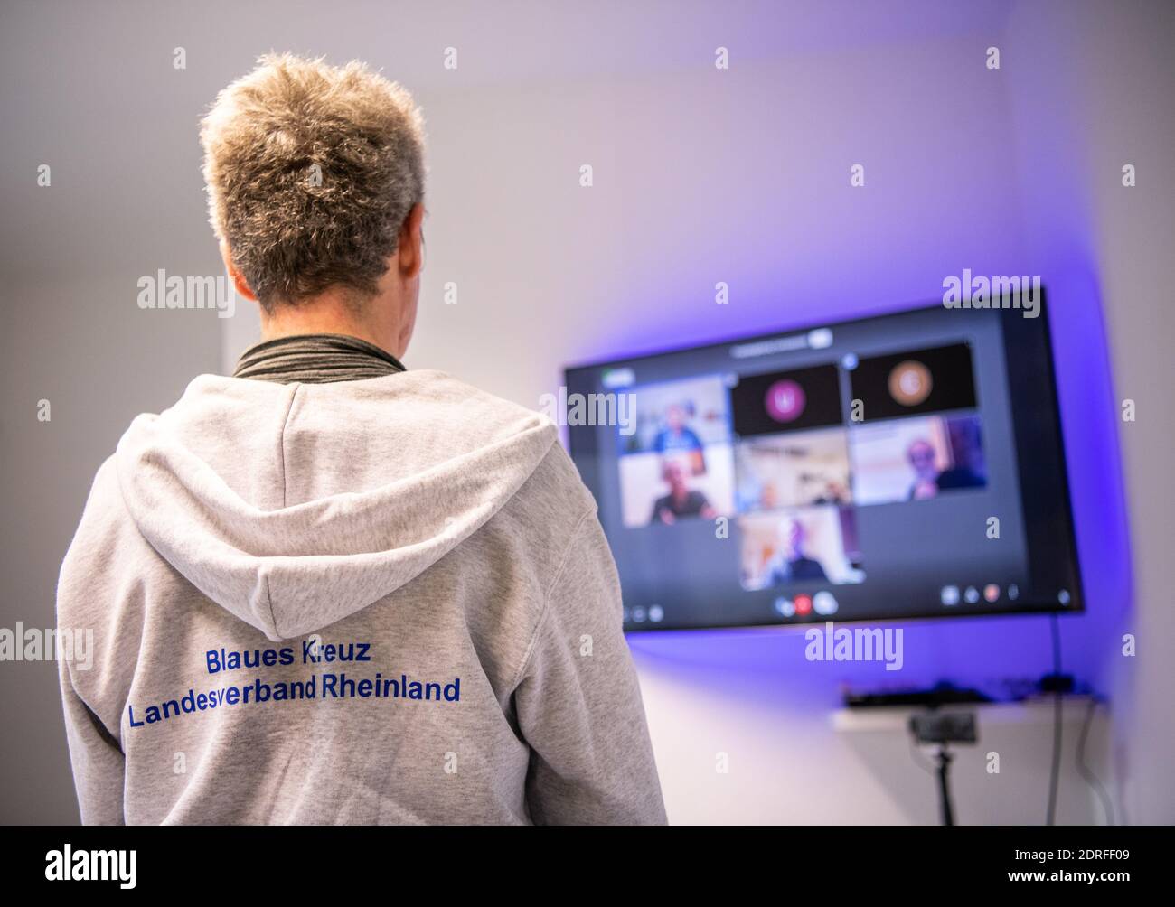 30. November 2020, Nordrhein-Westfalen, Remscheid: Michael Buchner, Gruppenleiter Blaues Kreuz Deutschland e.V., steht vor einer Leinwand mit einem Videotreffen. In Nordrhein-Westfalen waren Gruppenversammlungen nahezu universell möglich, da nach Ziffer 7 der Corona-Schutzverordnung Selbsthilfeangebote zu den "weiteren außerschulischen Bildungsangeboten" gehören. Dennoch haben die Gruppen der Suchtselbsthilfe derzeit auch andere kommunikative Wege vielerorts genutzt und nutzen sie noch. Vom Telefon, zum Walk-in-Pairs, Whats-App-Gruppen, Chats oder Videokonferenzen. (t Stockfoto