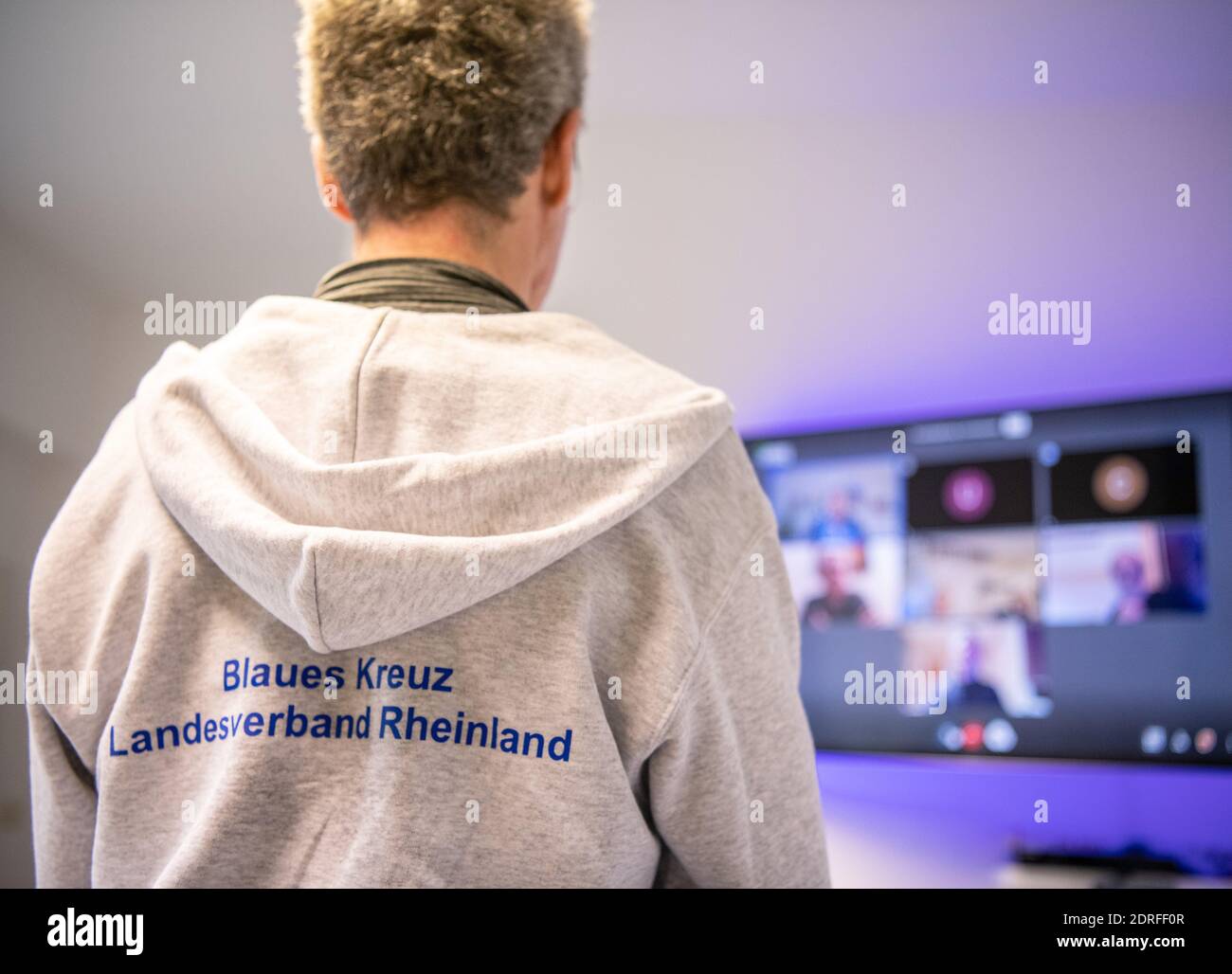 30. November 2020, Nordrhein-Westfalen, Remscheid: Michael Buchner, Gruppenleiter Blaues Kreuz Deutschland e.V., steht vor einer Leinwand mit einem Videotreffen. In Nordrhein-Westfalen waren Gruppenversammlungen nahezu universell möglich, da nach Ziffer 7 der Corona-Schutzverordnung Selbsthilfeangebote zu den "weiteren außerschulischen Bildungsangeboten" gehören. Dennoch haben die Gruppen der Suchtselbsthilfe derzeit auch andere kommunikative Wege vielerorts genutzt und nutzen sie noch. Vom Telefon, zum Walk-in-Pairs, Whats-App-Gruppen, Chats oder Videokonferenzen. (t Stockfoto