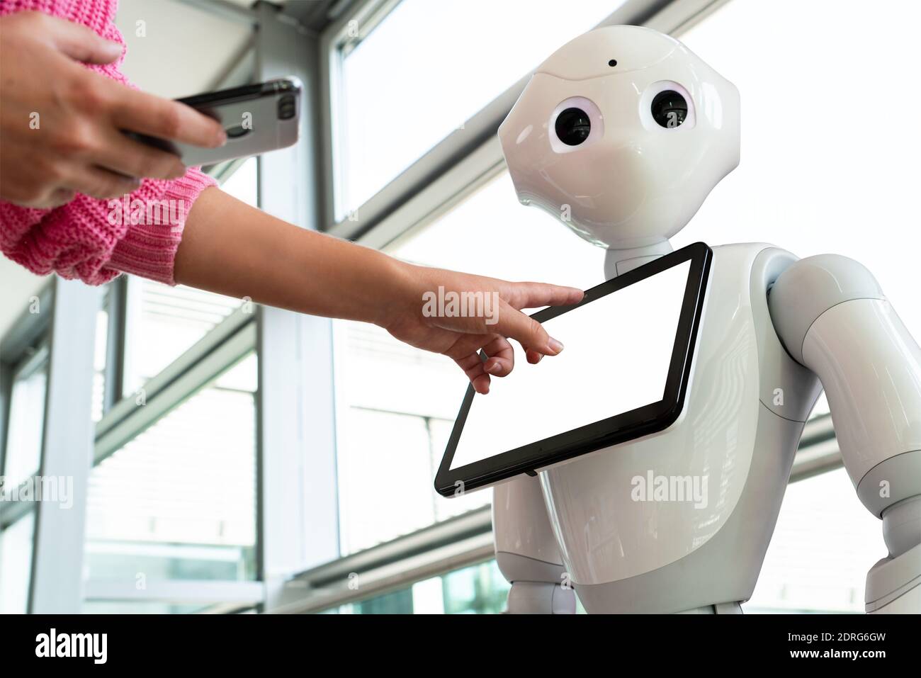 Eine Frau kommuniziert mit einem Roboter Berater Stockfoto