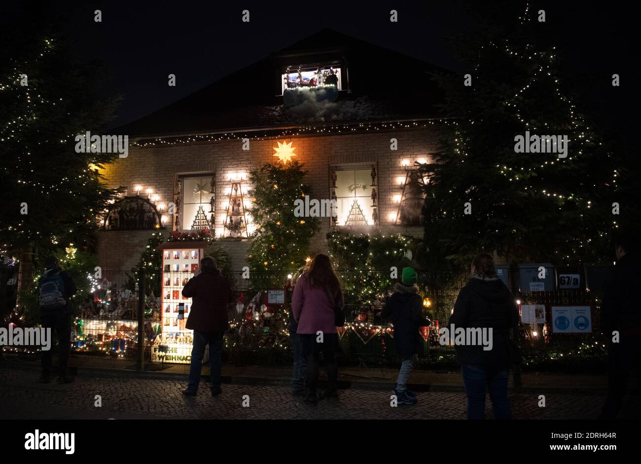 Berlin, Deutschland. Dezember 2020. Zahlreiche Menschen stehen vor dem Weihnachtshaus in der Oberfeldstraße in Biesdorf. Dort hat ein Hausbesitzer seinen Vorgarten in eine weihnachtliche Traumwelt verwandelt. Quelle: Paul Zinken/dpa/Alamy Live News Stockfoto