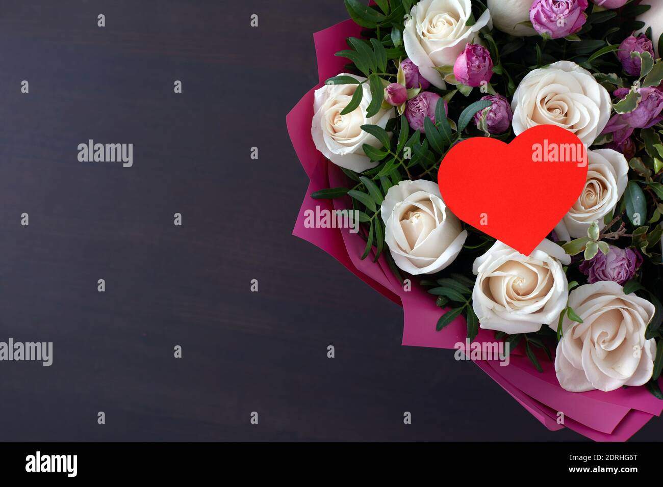 Valentinstag Grußkarte mit Rosenblüten Blumenstrauß dunklen Hintergrund mit Platz für Ihre Grüße. Draufsicht flach liegend Stockfoto