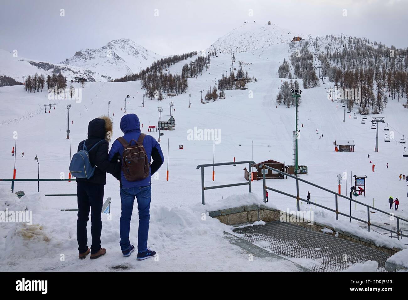 Skipisten wegen Pandemie über Weihnachten geschlossen, Paar schaut auf trostlos leere Pisten. Sestriere, Italien - Dezember 2020 Stockfoto