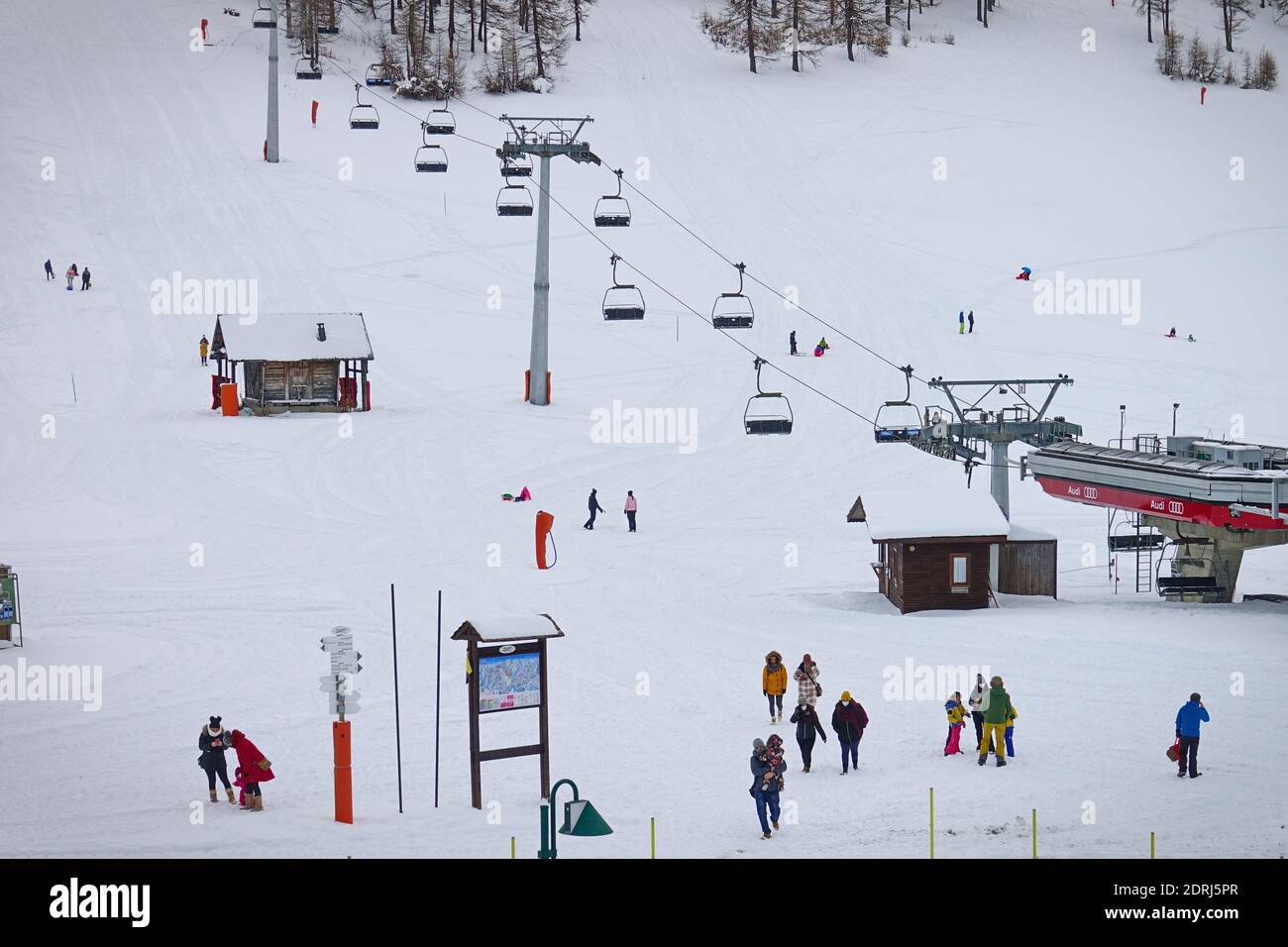 Skipisten wegen Pandemie über Weihnachten geschlossen, nur wenige Touristen mit Kindern spielen im Schnee mit Bob. Sestriere, Italien - Dezember 2020 Stockfoto