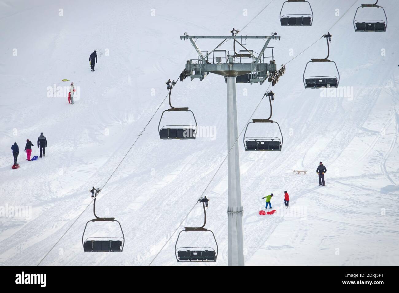Skipisten wegen Pandemie über Weihnachten geschlossen, nur wenige Touristen mit Kindern spielen im Schnee mit Bob. Sestriere, Italien - Dezember 2020 Stockfoto